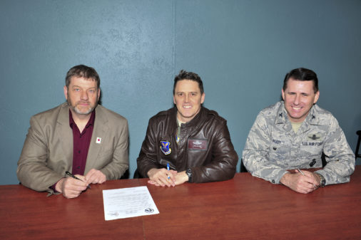 (left) Mark Vollmer, Minot Public Schools superintendent, (middle) Col. Jason Armagost, 5th Bomb Wing commander, and (right) Col. Thomas Rudy, 91st Missile Wing vice commander, prepare to sign a document for the adopt a school program in Minot , N.D., April 7, 2015. The document was a charter between the base and public schools where one of the base’s responsibilities is to provide volunteers to assist the schools with beautification, guest speakers, chaperones, etc…. (U.S. Air Force photo/Senior Airman Malia Jenkins)