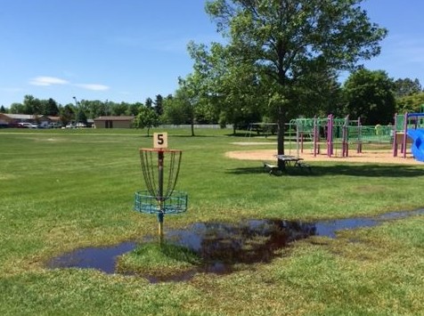The #5 basket at the Polaris Park disc golf course sits in a puddle of water after a recent rain.
