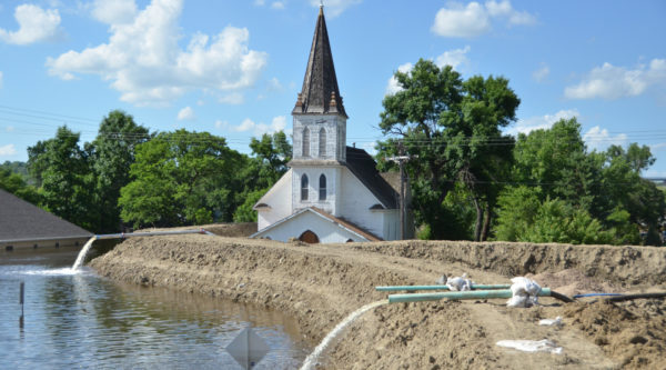 Minot's original Augustana Lutheran Church sits just behind temporary flood levees in 2011 at its location near Broadway and 4th Ave. NW. The church was later demolished. Image courtesy of FEMA.